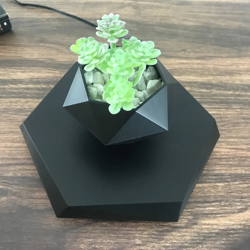 Hexagonal wood grain magnetic levitating flower pot floating above a circular black base on a desk.