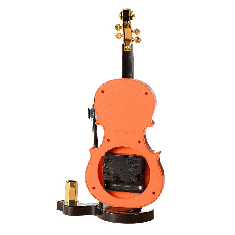 Brown plastic violin pen inserted alarm clock with quartz movement and LED display on a desk