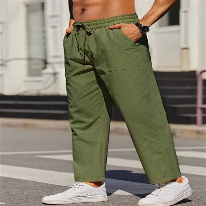 Men's straight-leg linen trousers in a solid colour, showing the elasticated mid waist and long leg.