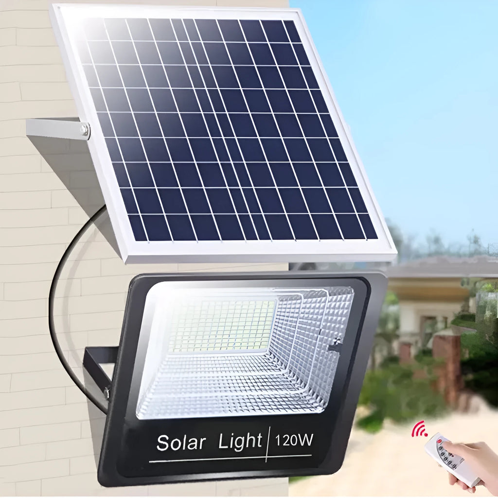 Black solar-powered outdoor LED flood light with remote control on a garden wall.