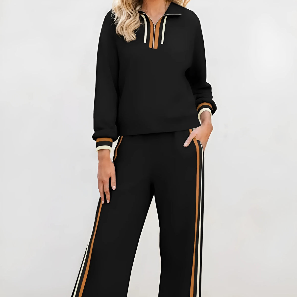Black striped patchwork quarter zip pullover and loose pant set on a plain background