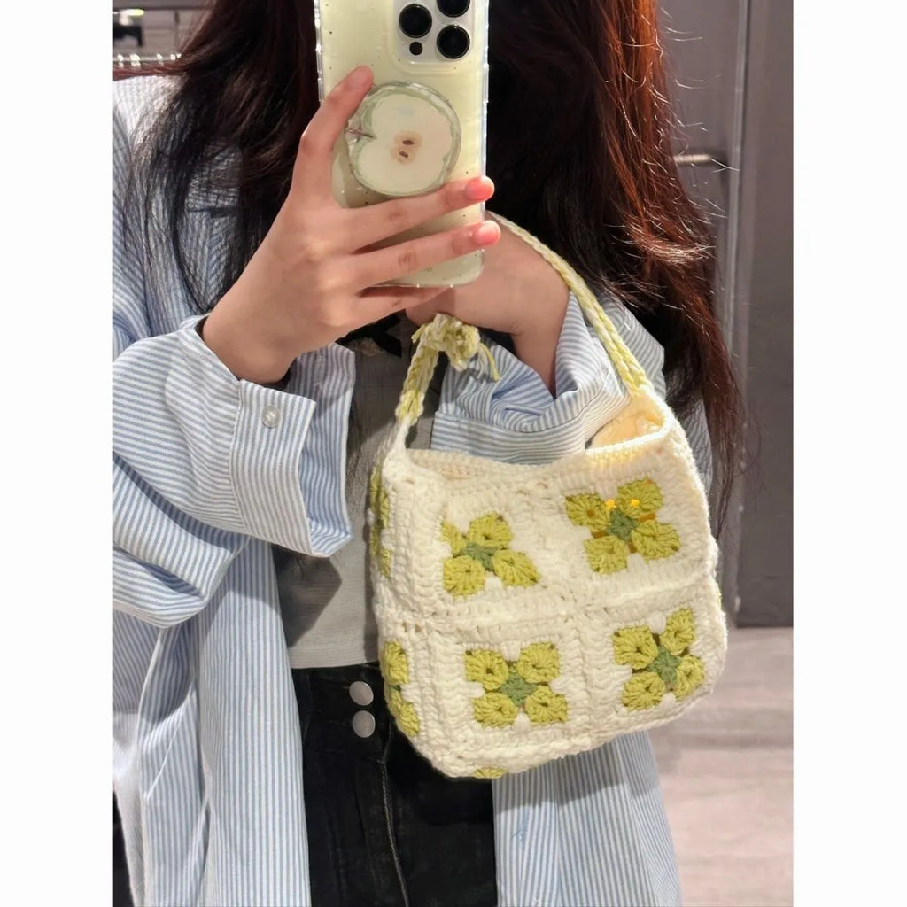 Handmade pink crochet handbag with cherry blossom design and magnetic buckle.