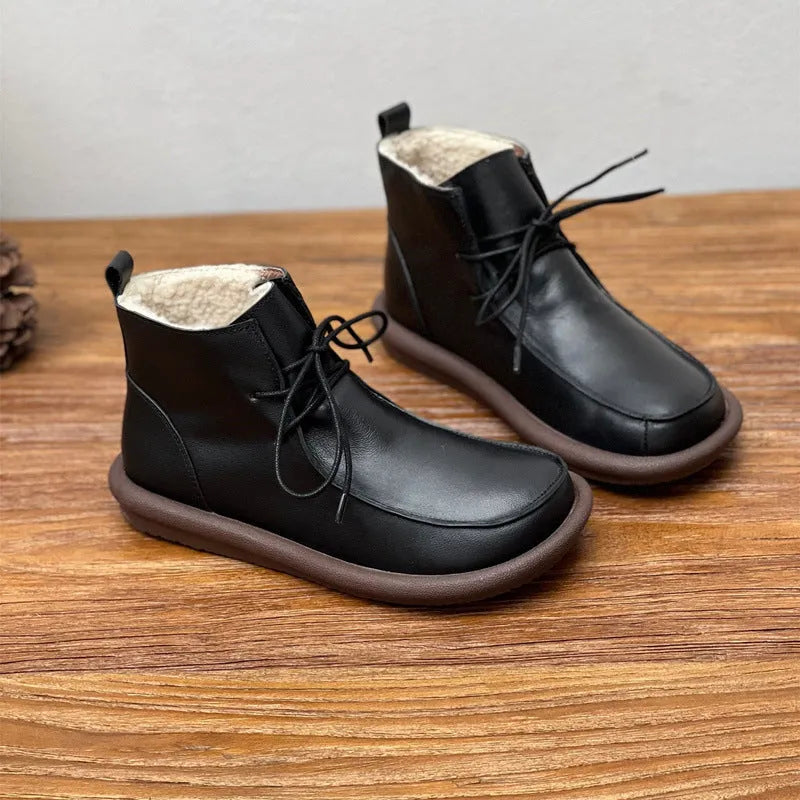 Women's black cowhide boots with a flat heel and round toe, featuring a velvet lining.
