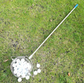 Metallic stainless steel golf ball picker on green grass