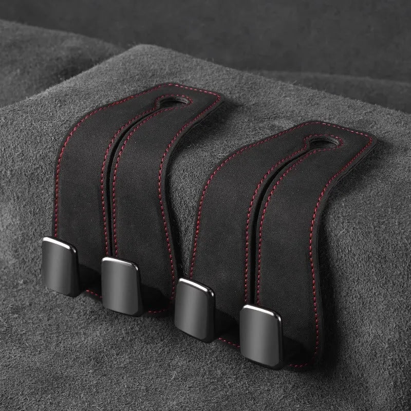 Black suede and metal car seat hook organiser hanging on a car headrest.