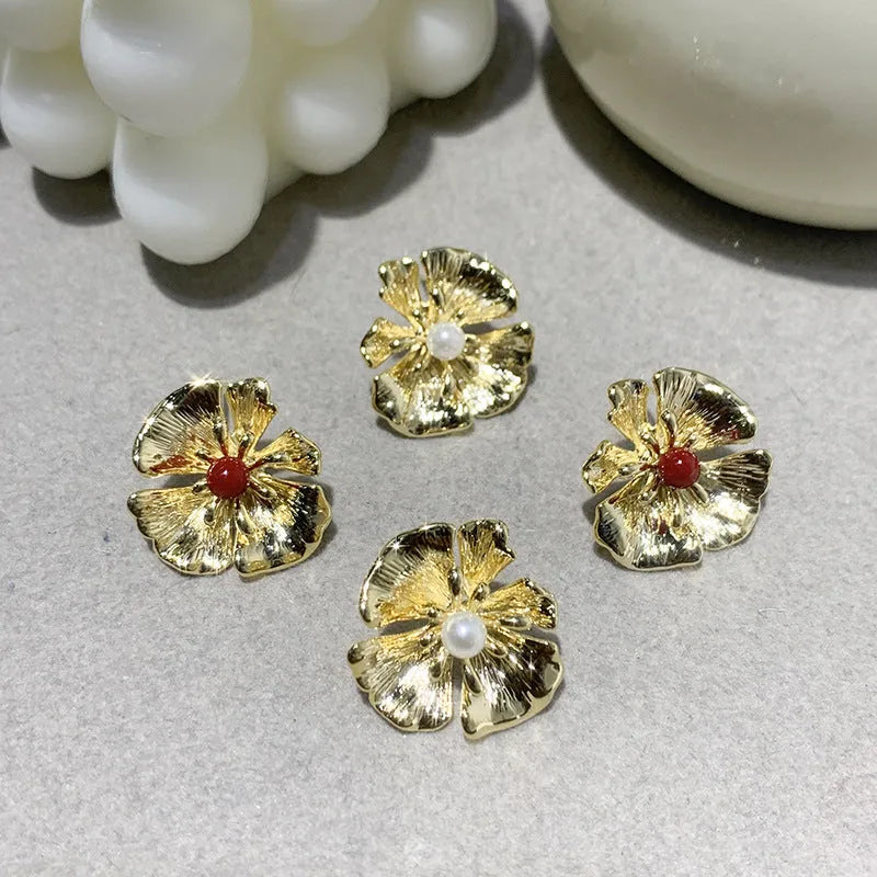 Pearl flower shaped metal earrings in red and white colour options on a grey background