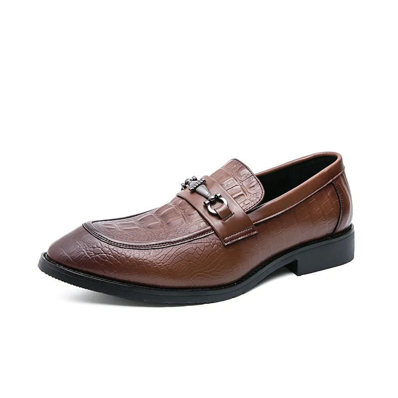 Men's black slip-on formal shoes with pointed toe and belt buckle detail on a light background