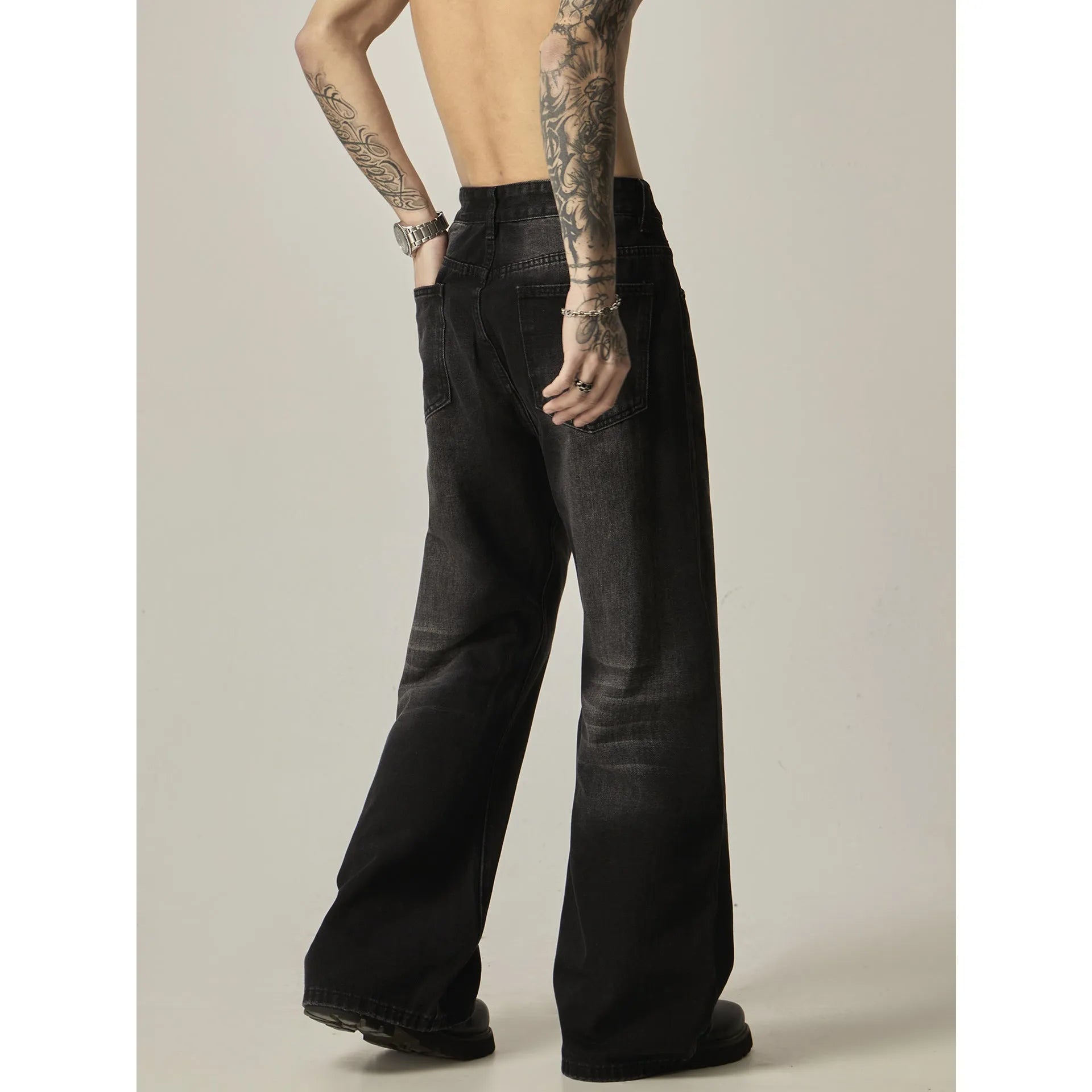 Black loose straight retro jeans with zipper fly closure on plain background
