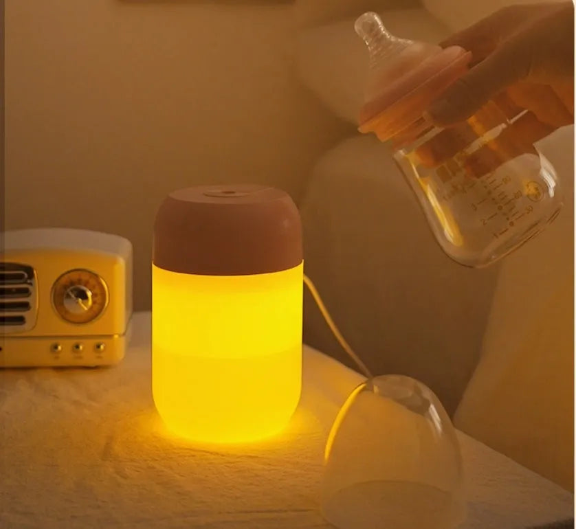 White cylindrical USB mini humidifier with charging cable on wooden desk