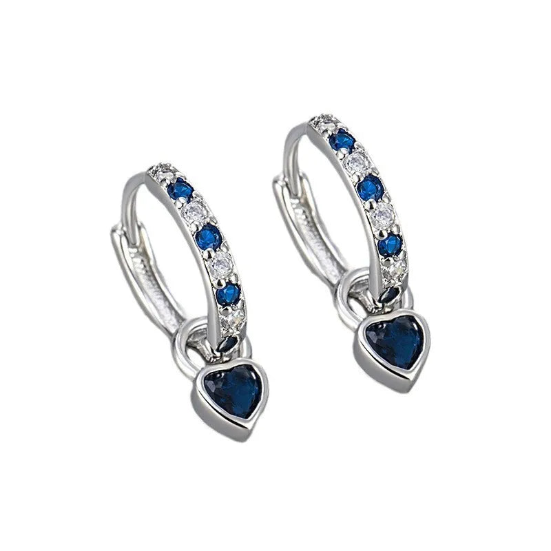 Gold colour heart-shaped clip earring with a central blue zircon stone on a white background.