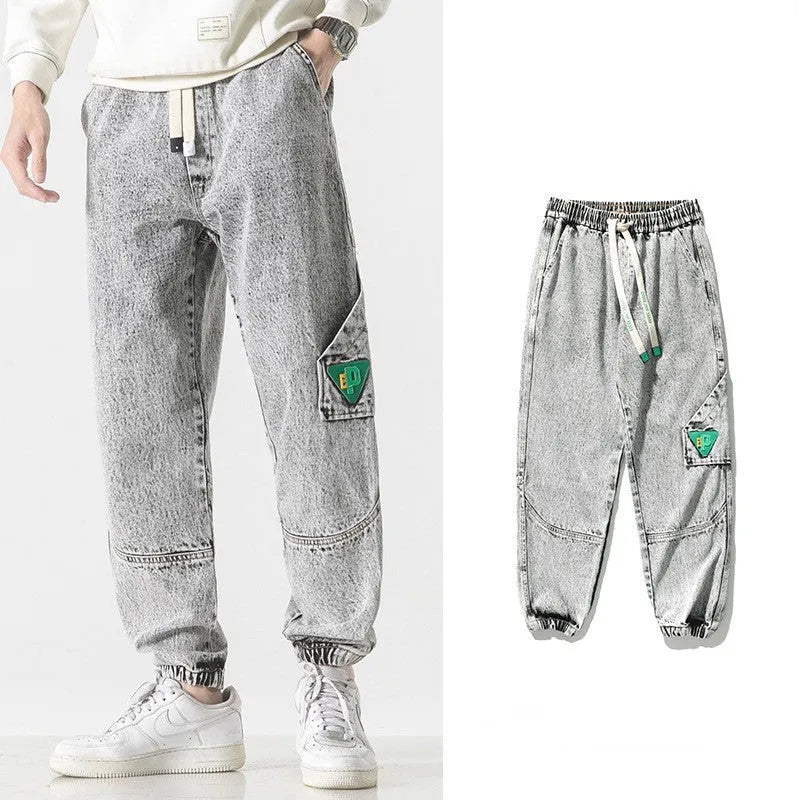 Men's loose-fit tapered cotton trousers in black showing mid-waist design and tapered leg cut