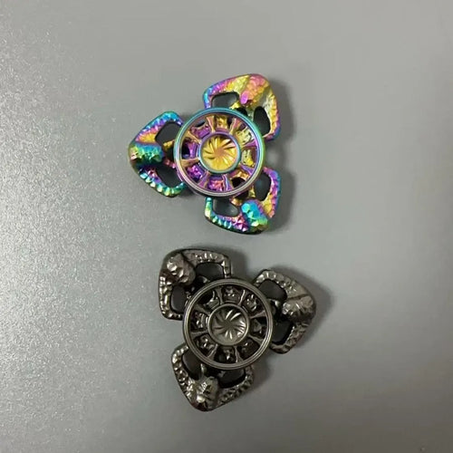 A metal butterfly-shaped fingertip gyro fidget toy spinning on a surface.