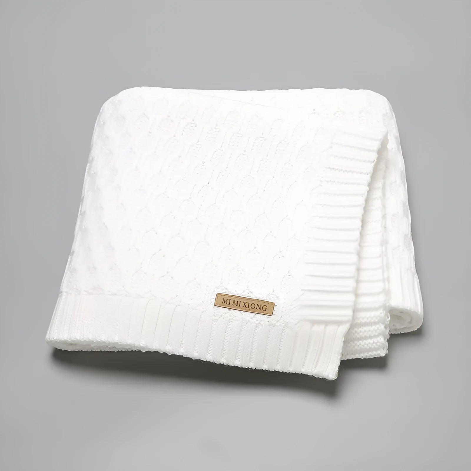 Solid colour infant blanket with raised line texture in beige khaki, laid flat showing 70x90cm size.