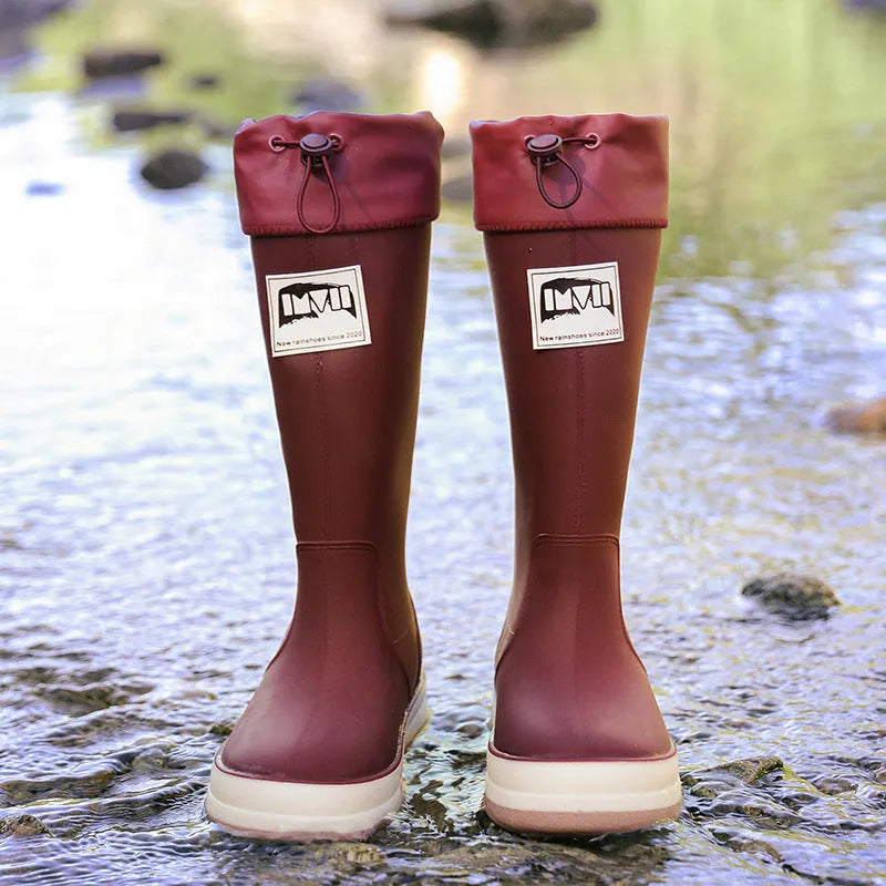 Pair of solid colour high tube PVC rain boots with a low heel on a non-slip sole.