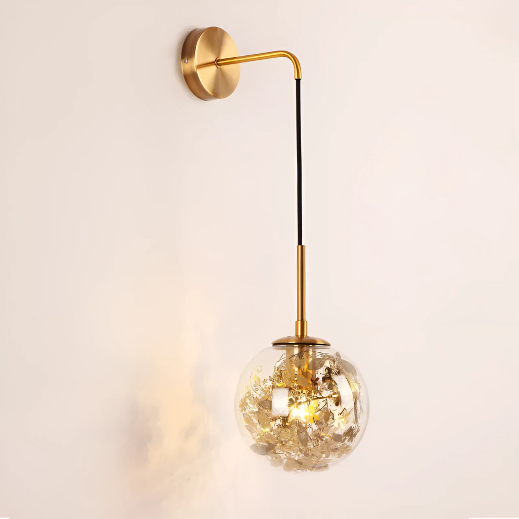 Modern glass wall mounted bedside lamp in golden flower finish on a white wall.