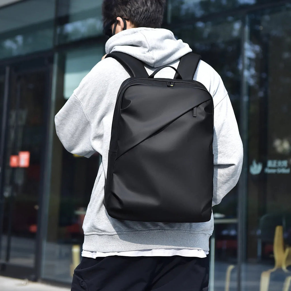 Men's waterproof backpack in black, blue or grey colour with PU leather construction and sewing thread detailing