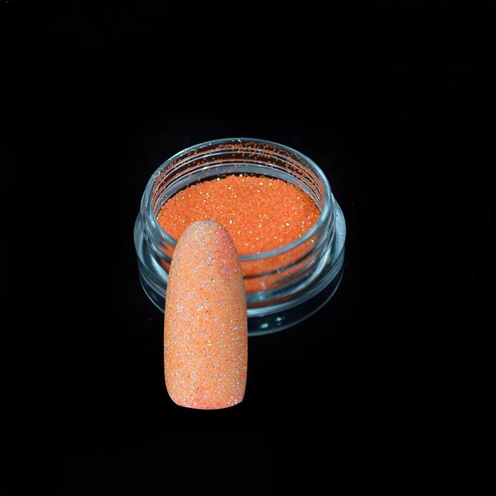 Six 1g pots of neon nail glitter powder in blue, green, orange, pink, purple, and yellow colours on a white background