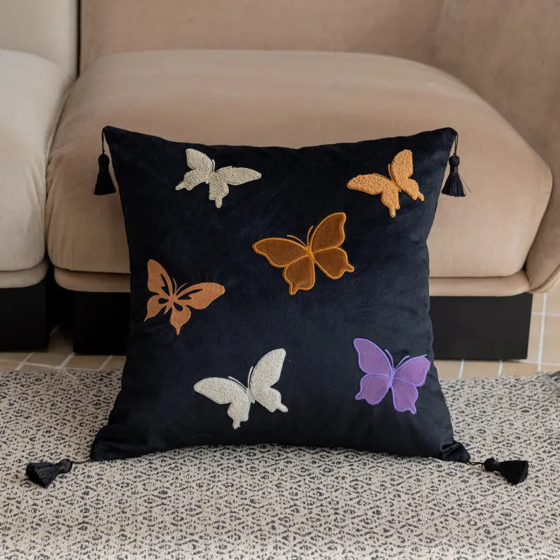 Square decorative cushion with Chinese butterfly embroidery in beige, black, and purple threads.