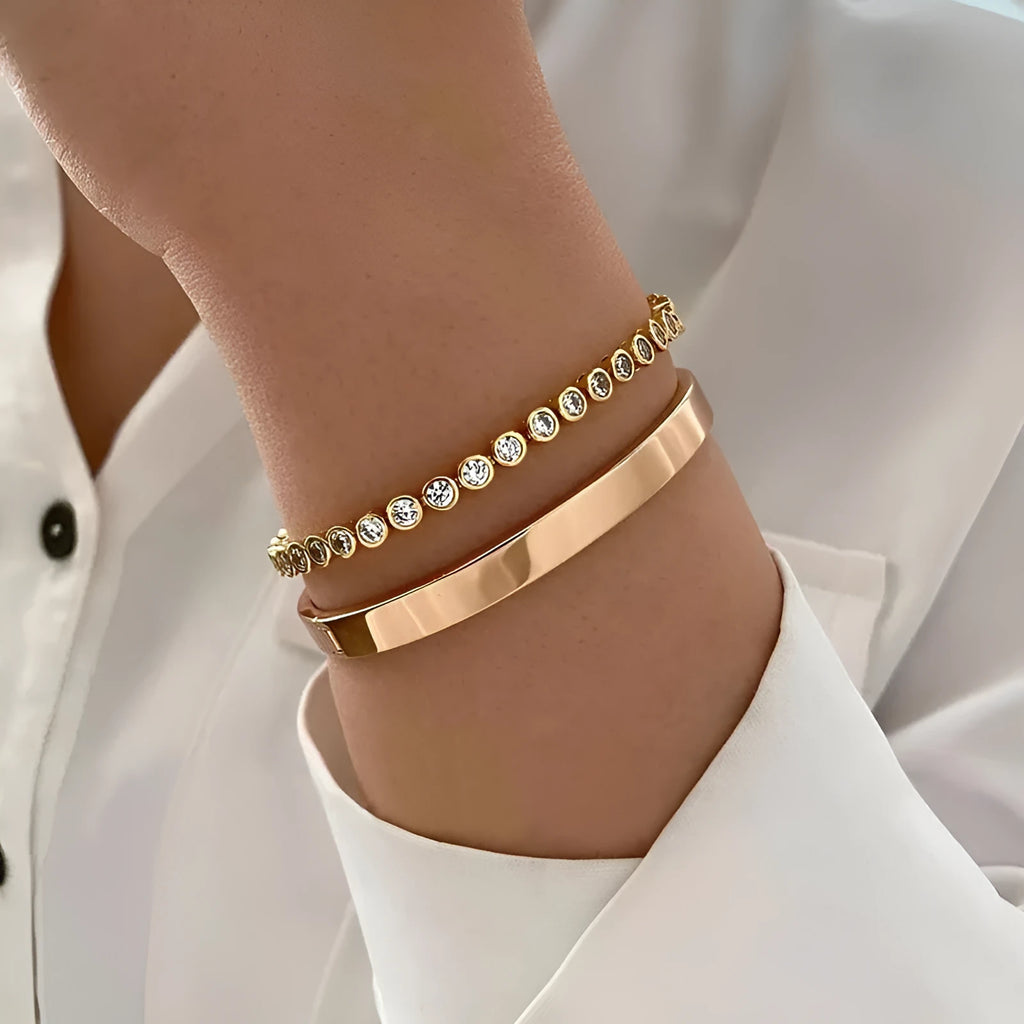 Two vintage drop-shaped geometric bracelets in gold and silver, side by side