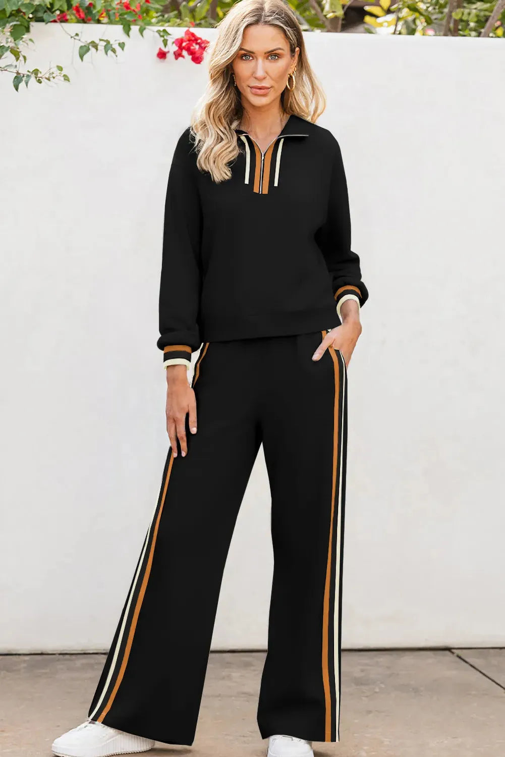 Black striped patchwork quarter zip pullover and loose pant set on a plain background