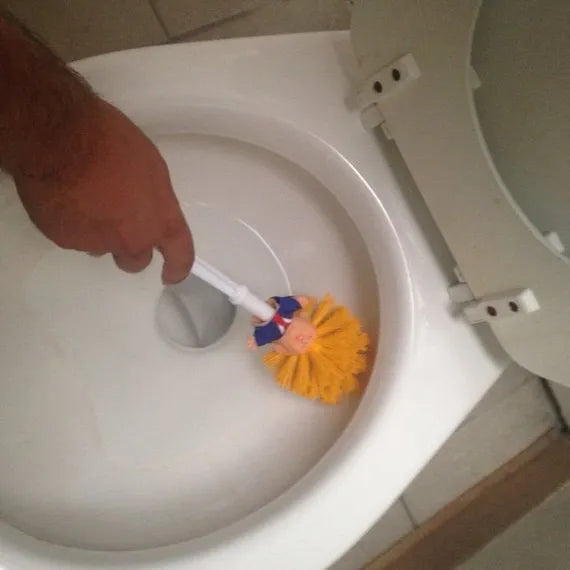 Yellow plastic Donald Trump toilet brush with hanging slot on handle.