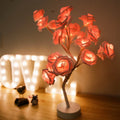 White and red rose flower LED table lamp with bonsai tree lights on a table.