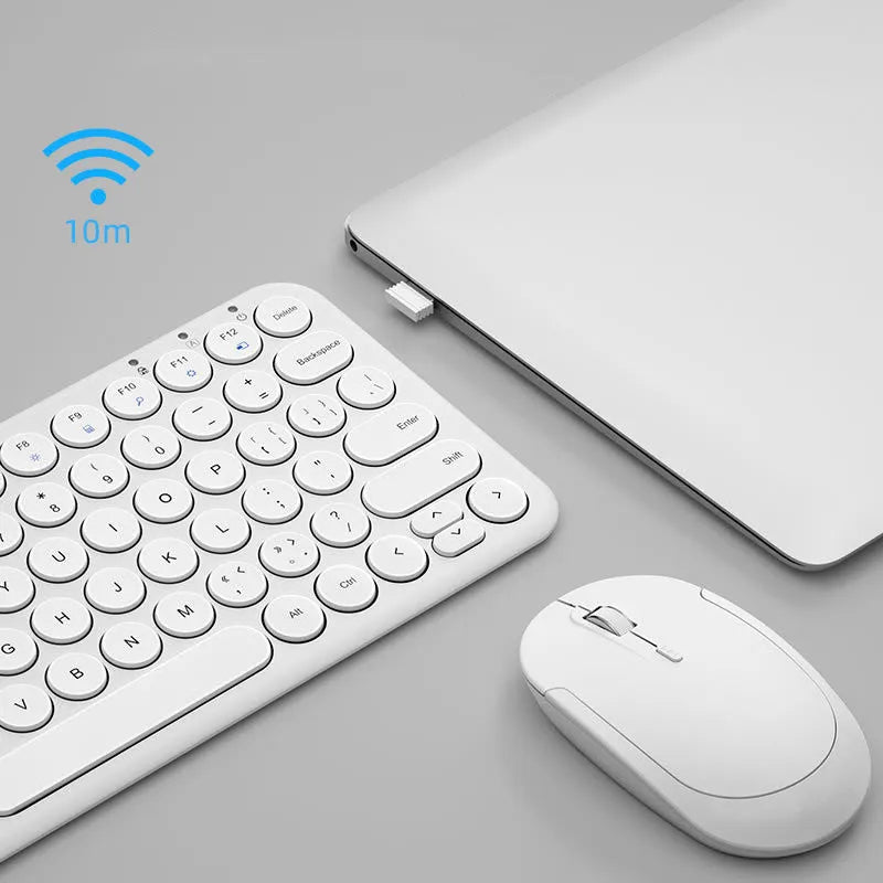 Ultra-thin white wireless keyboard and mouse set with USB dongle on a wooden desk.
