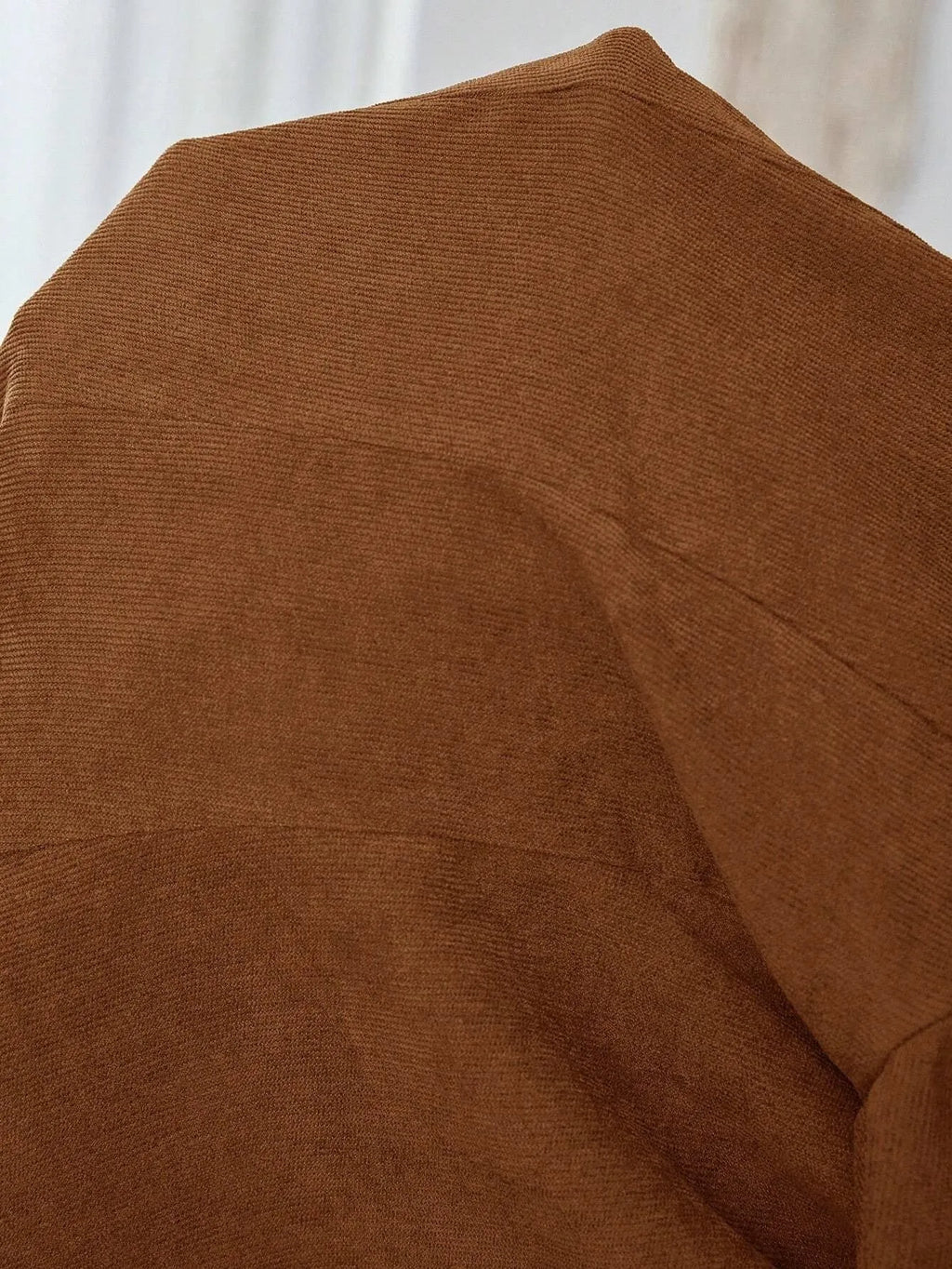 Brown single-breasted lapel leisure suit coat with long sleeves on a hanger