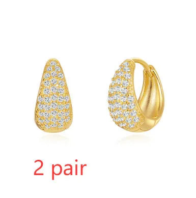 A pair of gold tone geometric earclip earrings with a round design and screw-back mechanism.