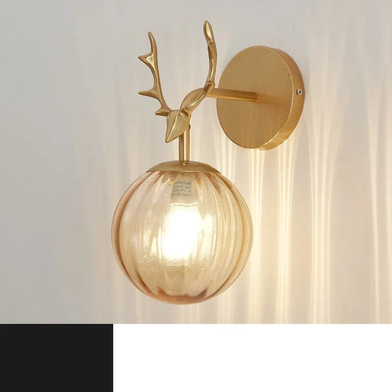 Round glass Nordic wall lamp with golden water pattern finish on a white wall.