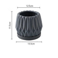 A simple grey ceramic flowerpot on a tabletop, medium sized for plants.