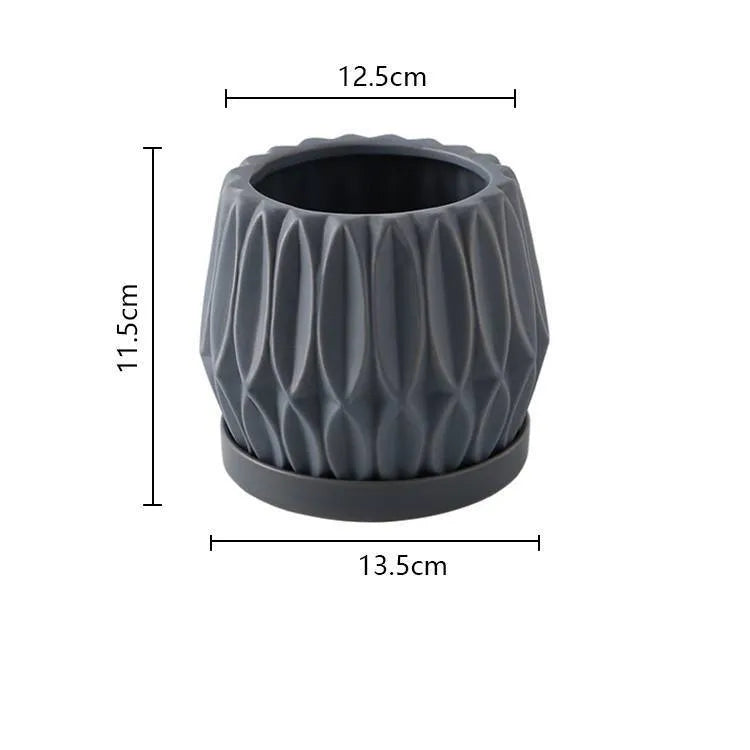 A simple grey ceramic flowerpot on a tabletop, medium sized for plants.