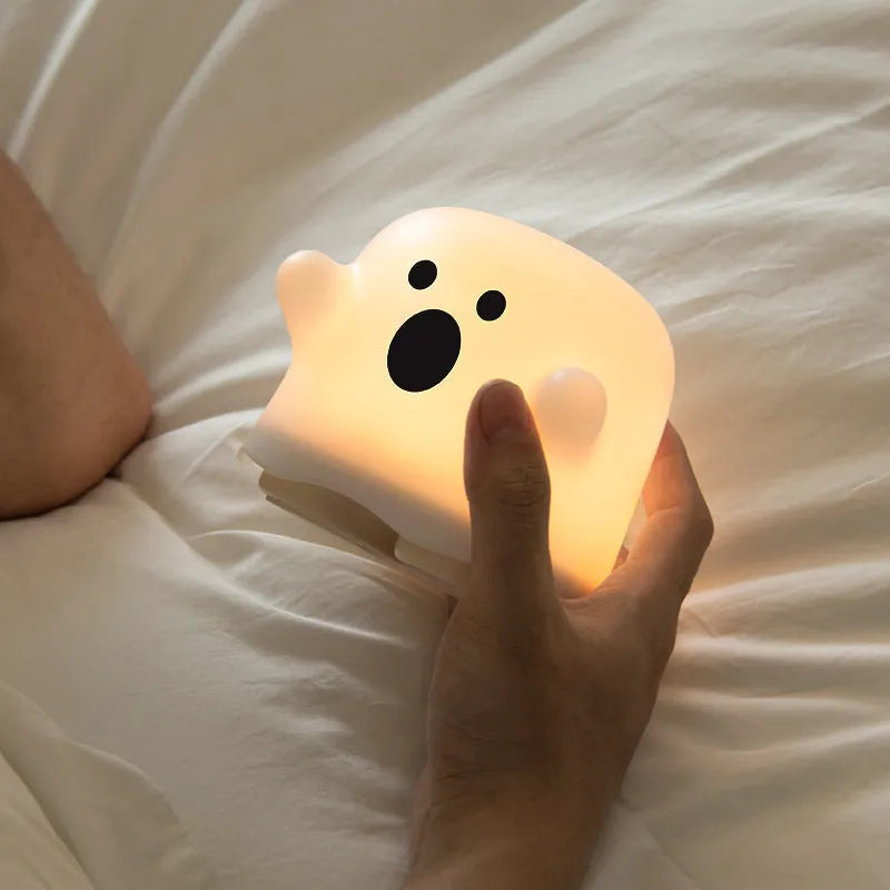 White silicone bedside night light with touch sensor base on wooden table