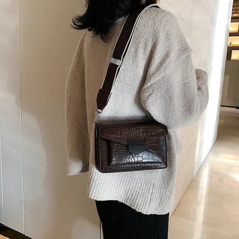 Vintage PU leather crossbody bag in black, shown with a mobile phone and wallet inside