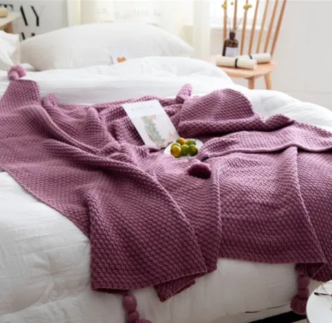 Acrylic knitted fringed blanket in beige colour on a sofa, showing texture and size.