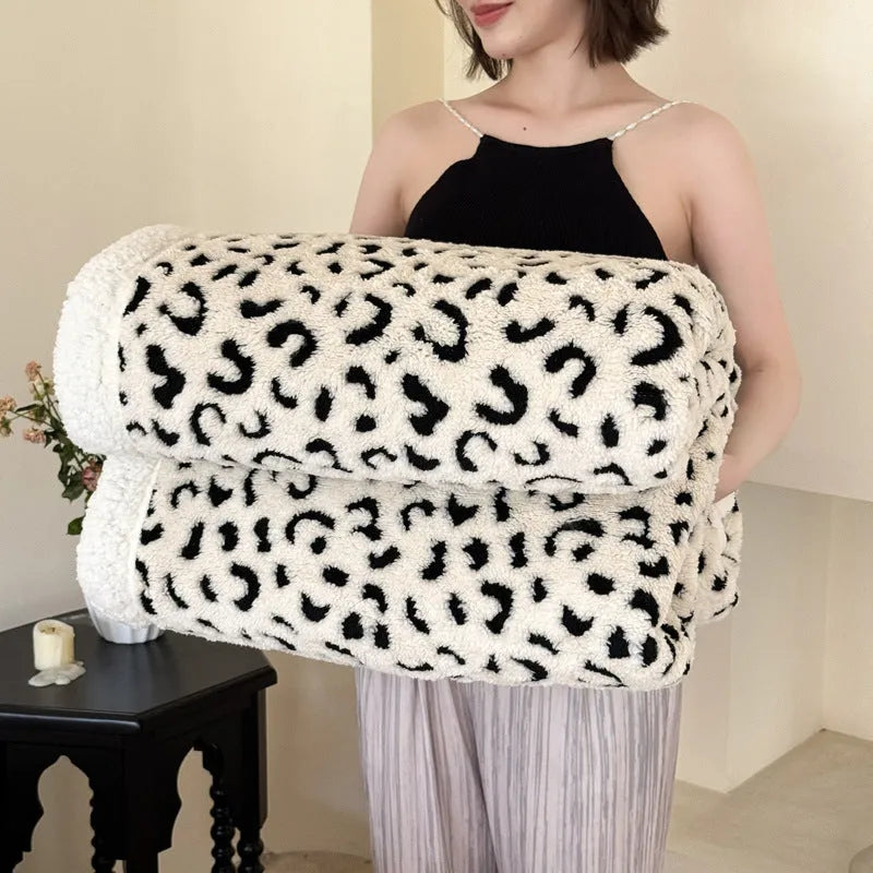 Double-layer taffeta blanket with woven leopard print pattern draped over sofa