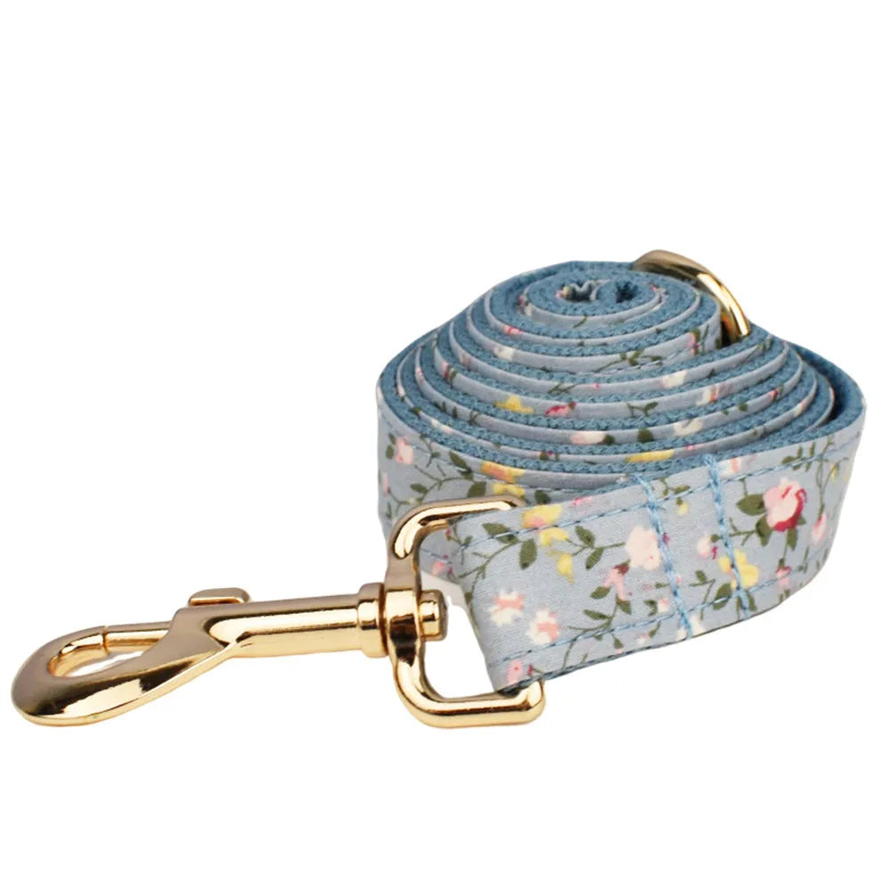 Blue floral patterned dog collar set with matching leash, bow, vest, and poop bag accessories