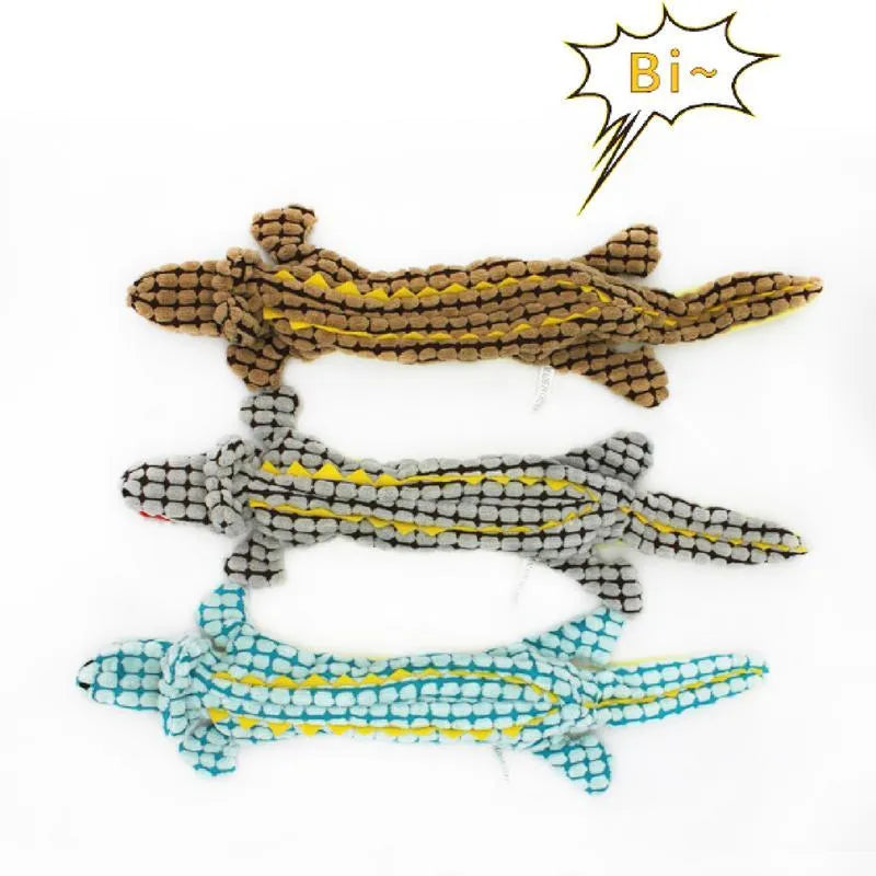 Blue crocodile-shaped plush squeaky dog toy with corduroy fabric on a wooden floor.