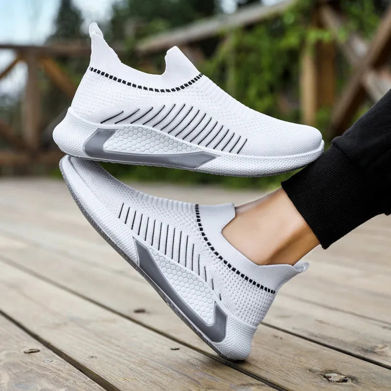 Men's black and white striped slip-on sneakers with lace-up front and mesh design.