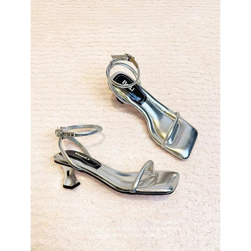 Black women's high heel sandals with a single buckle strap, square toe, and a chunky thick heel.