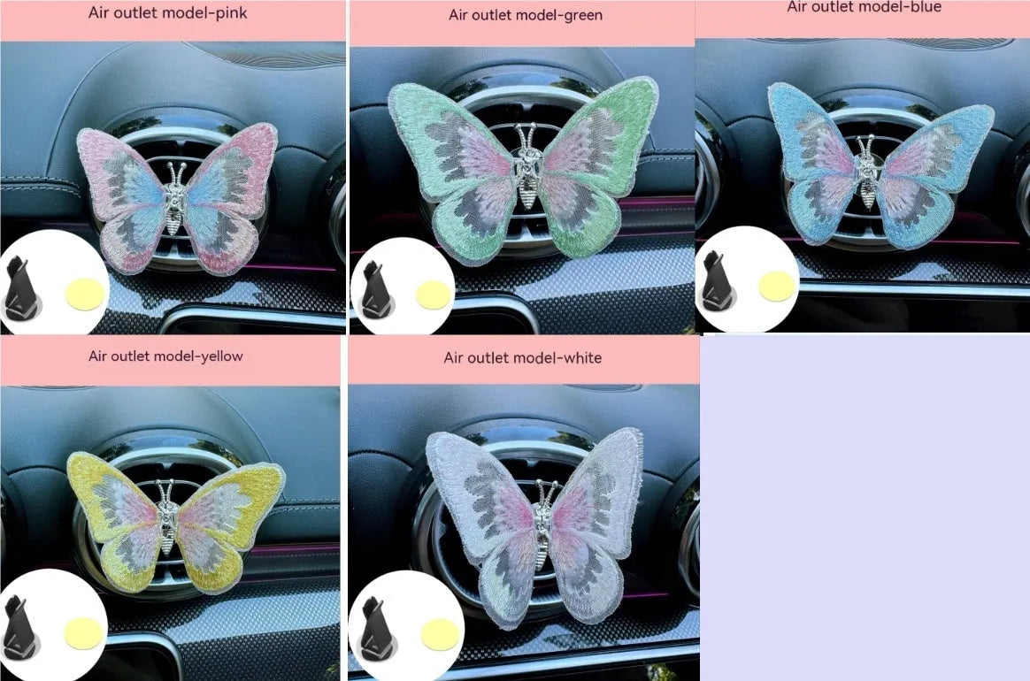 Fabric embroidered butterfly car air vent decoration in multiple colour options on a dashboard.