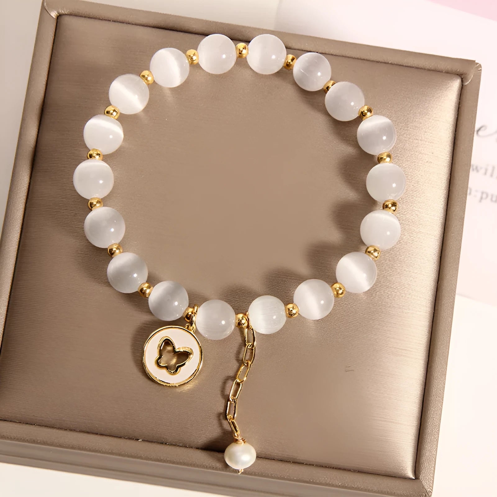 White Cat's Eye crystal bracelet with geometric links on a wrist.