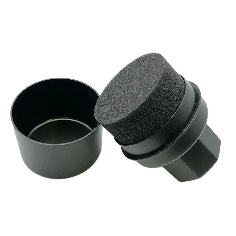 Black and red hand-held car tyre polishing sponge brushes with lids on a workbench.