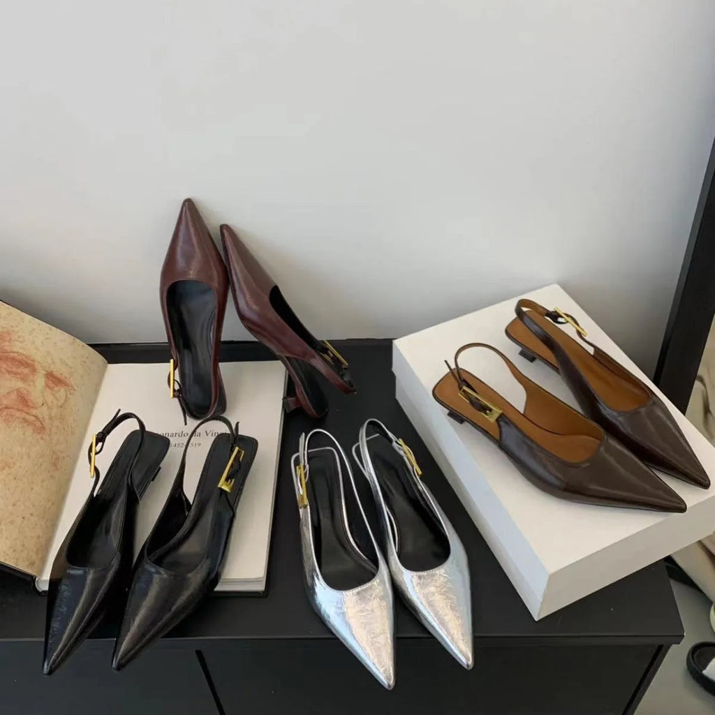 Women's black leather pointed-toe shoes with a thin low heel and an ankle strap.