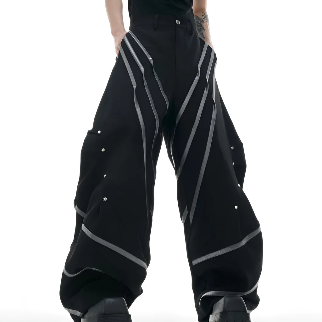 Men's polyester trousers with pleats and metal rivet detailing, shown in black and white colour options.