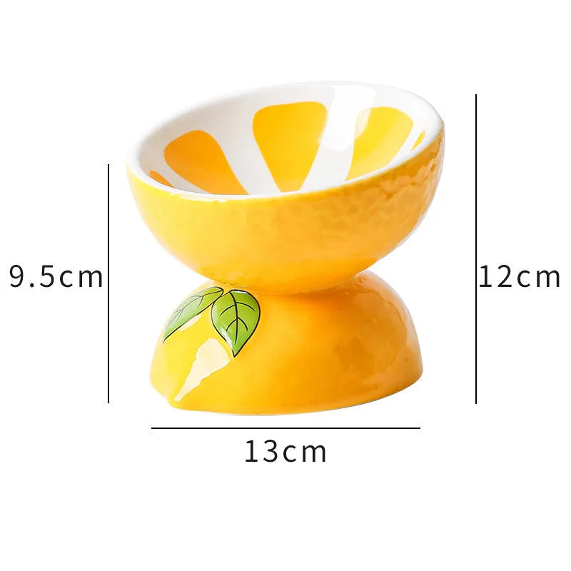 Ceramic elevated cat bowl with tilted orange fruit pattern and non-slip base.