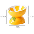 Ceramic elevated cat bowl with tilted orange fruit pattern and non-slip base.