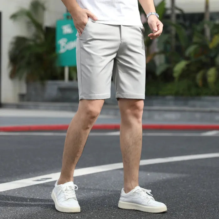 Man wearing loose-fit beige mid-length casual trousers with an elasticated waistband.