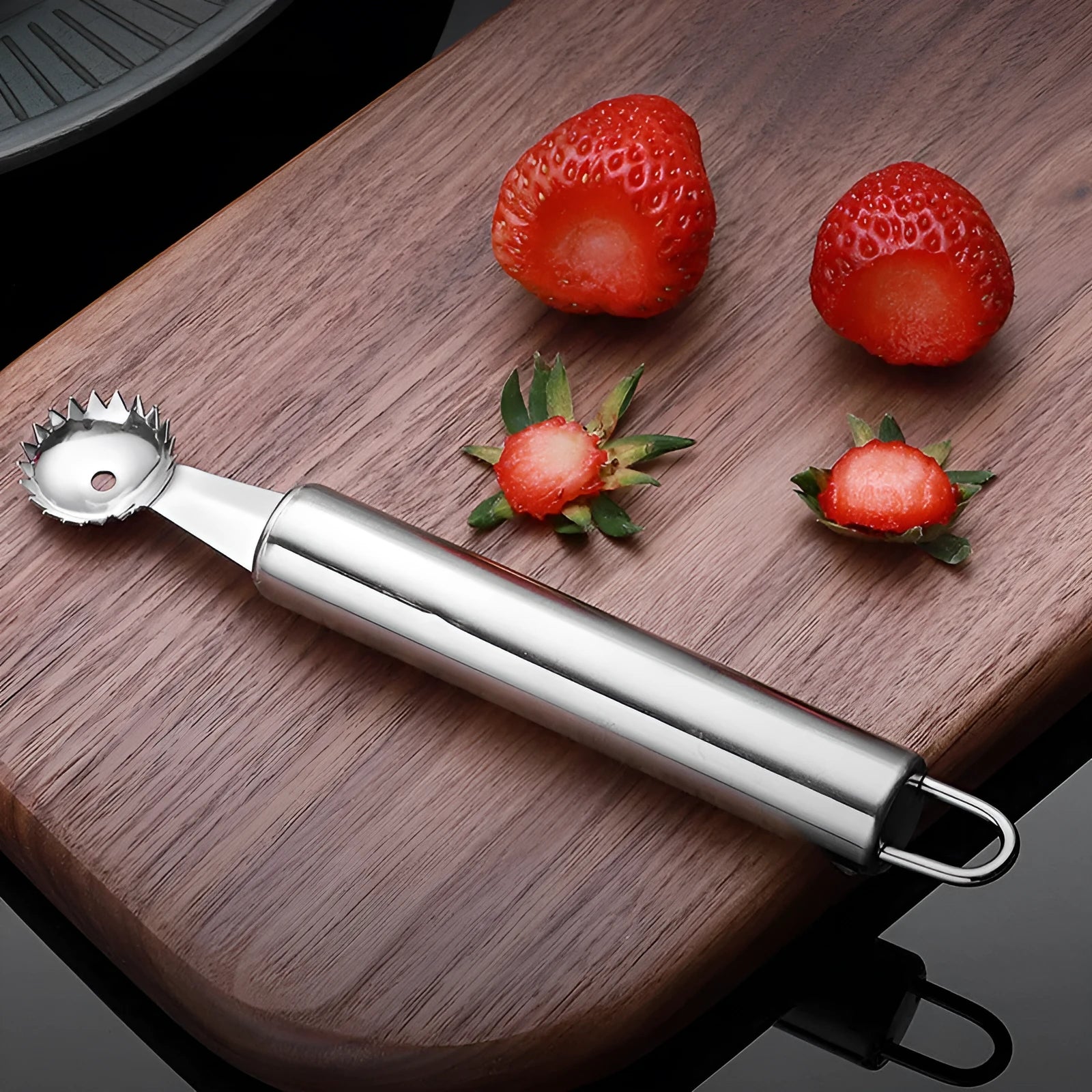 410 stainless steel strawberry stem remover on a light background, showing handheld design