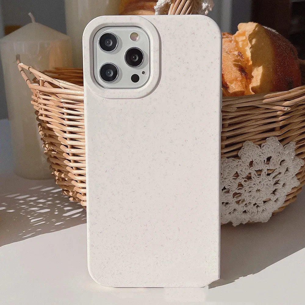 Degradable wheat straw phone case for Apple iPhone on a wooden surface.